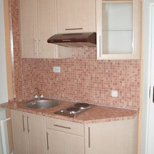 Небольшая бежевая кухня со стеклом